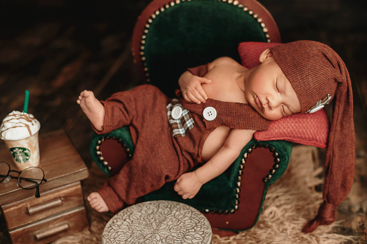 Newborn boy in studio  in Greater Toronto Photo studio  laying sleeping on a green sofa .
