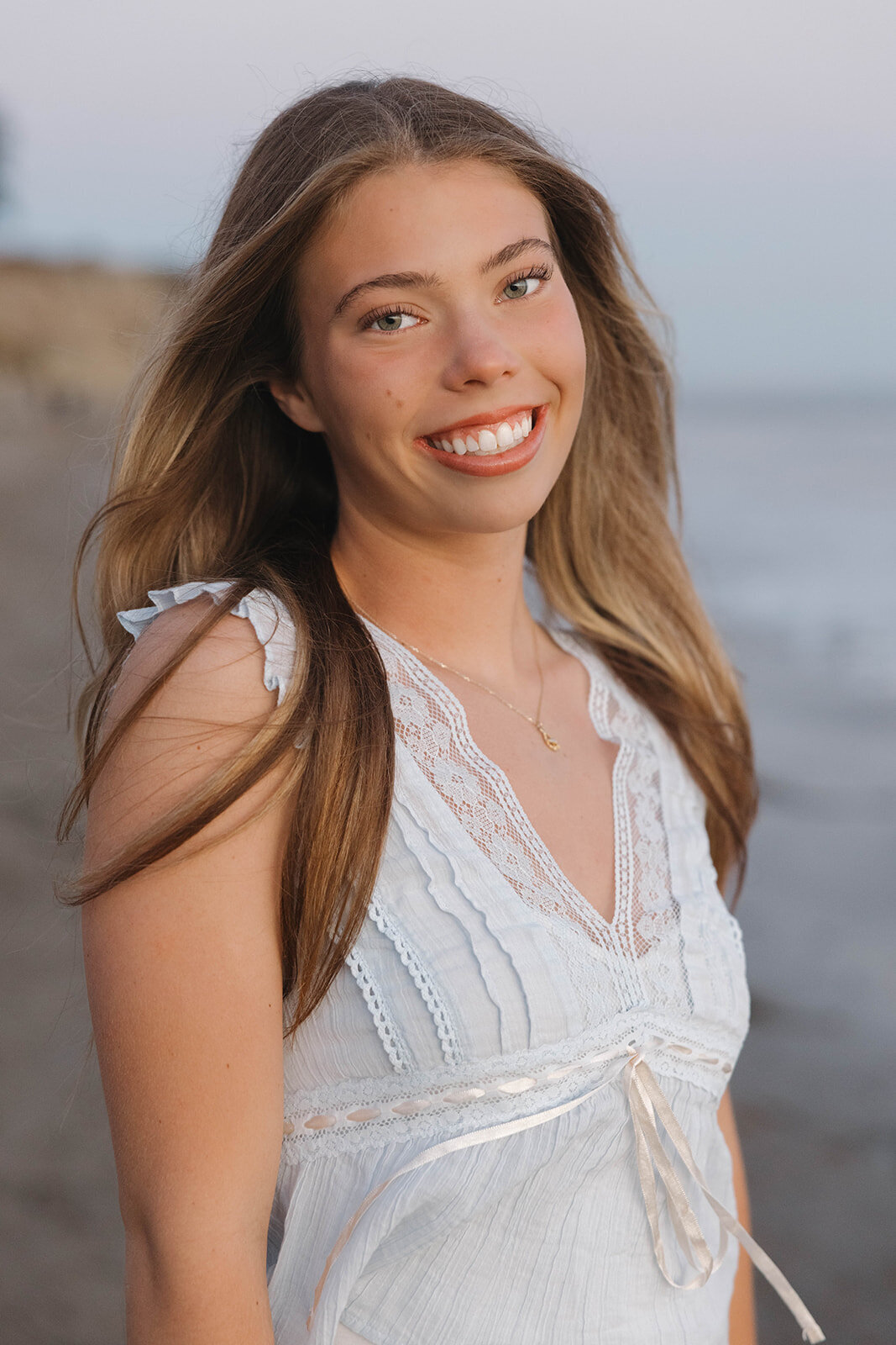 Smiling senior girl on the beach at sunset