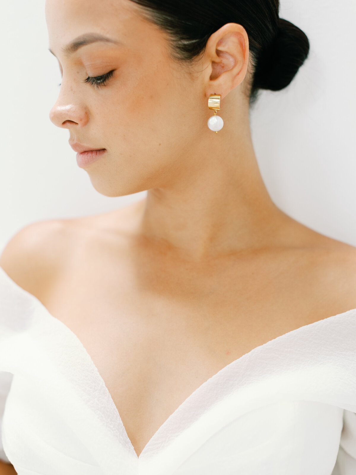 A front view of bride with a sweetheart front dress and earrings