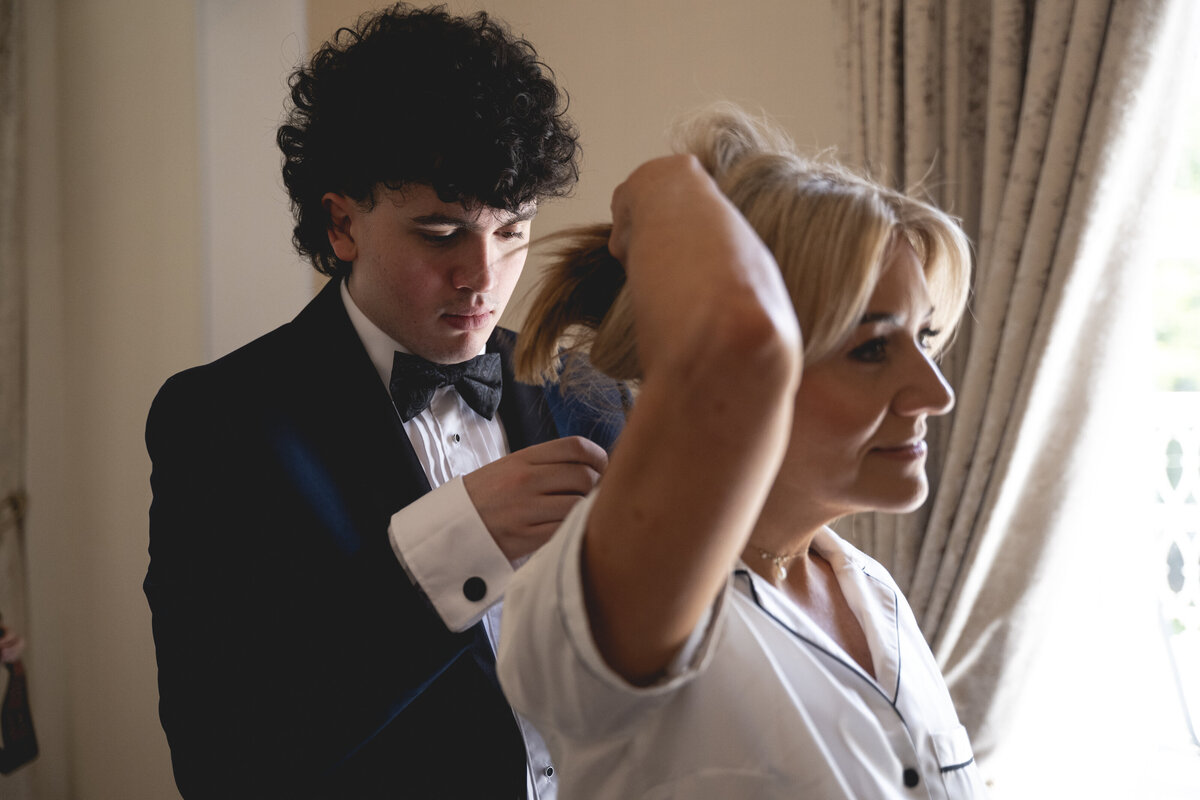 Jill's son helping her with her necklace