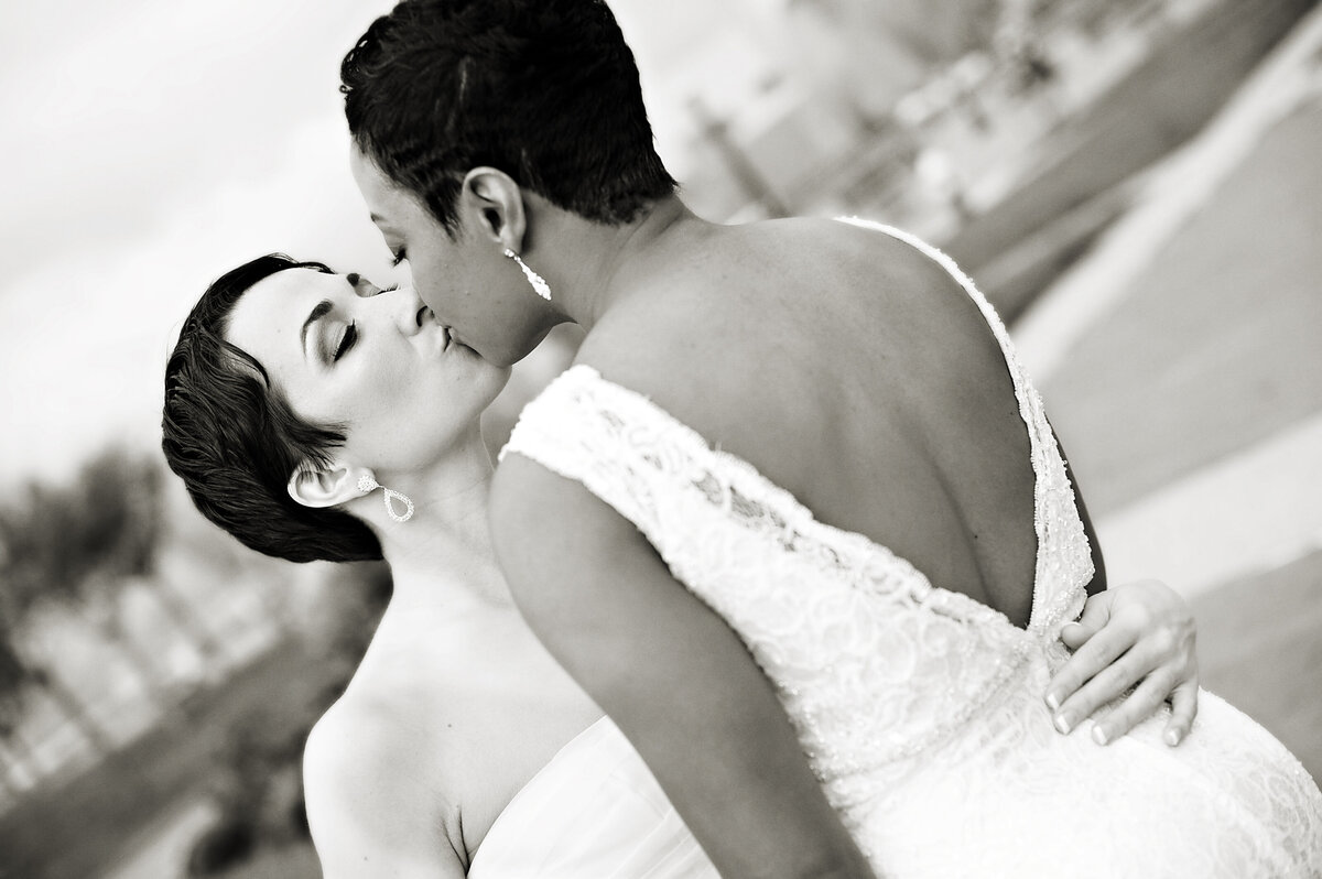 A wedding couple kissing with their arms around each other 