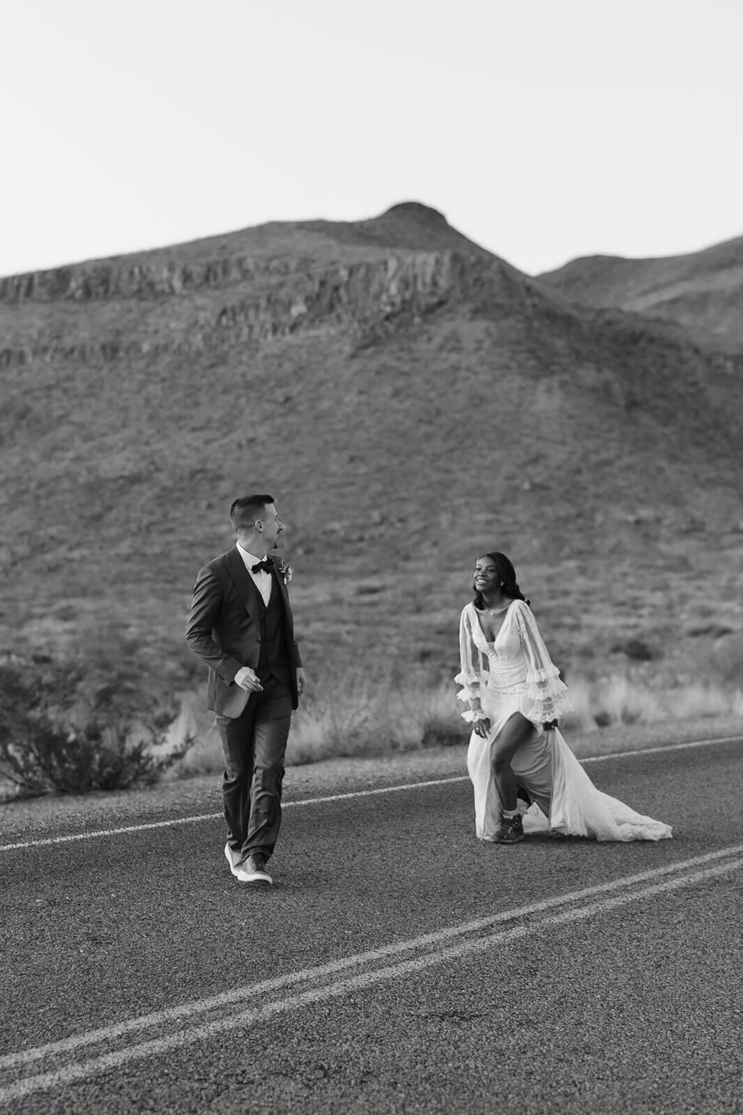 bride chases after her husband on a mountain road