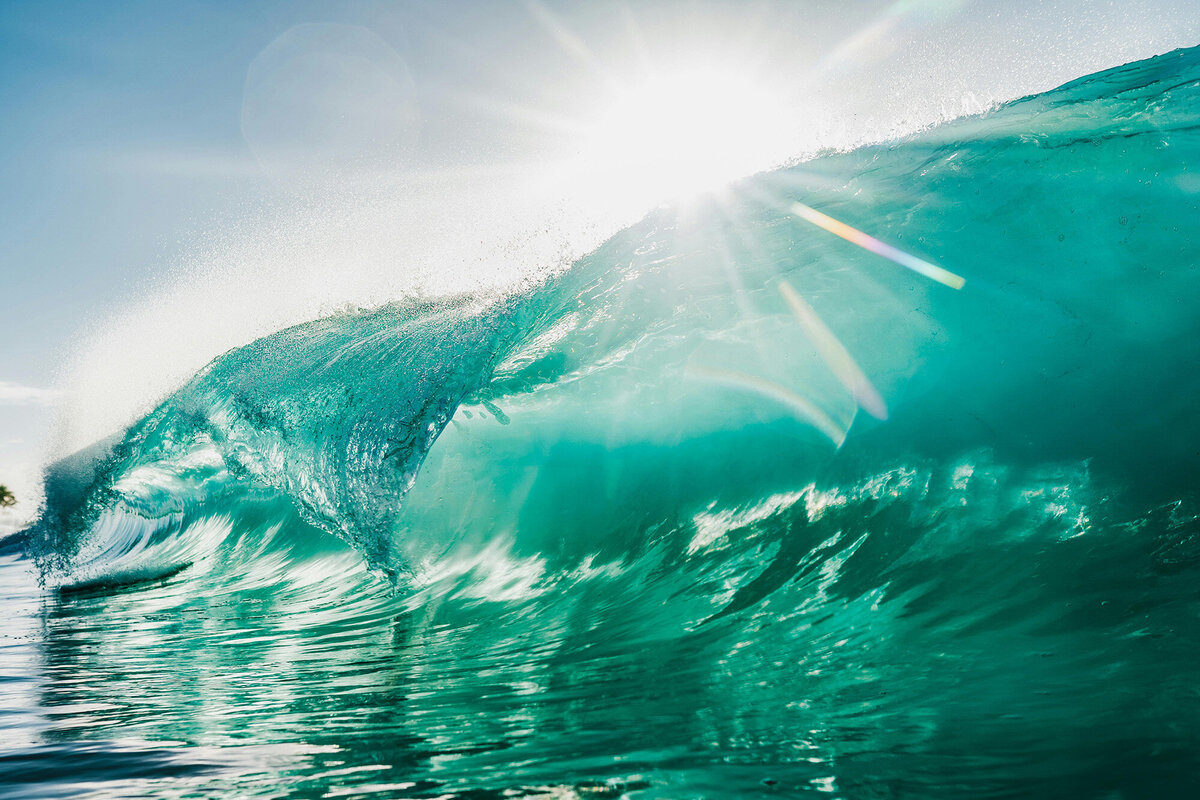 Close-up of a turquoise wave breaking with a sun starburst, symbolizing financial clarity, freedom, and empowerment. At Ataraxis Financial, we go beyond bookkeeping—we provide financial clarity, strategic insights, and stress-free solutions so you can focus on scaling your business and experiencing life fully.
