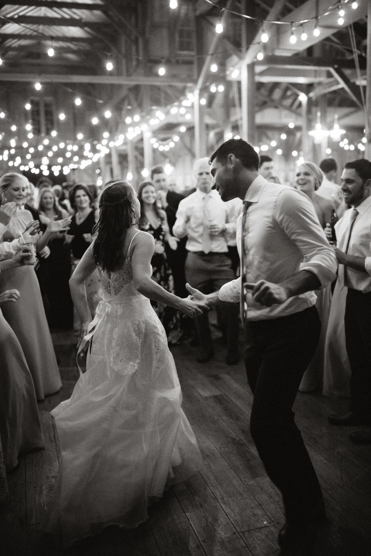 Bride and groom photographed enjoying their wedding reception with all their friends and family at Grace Winery.