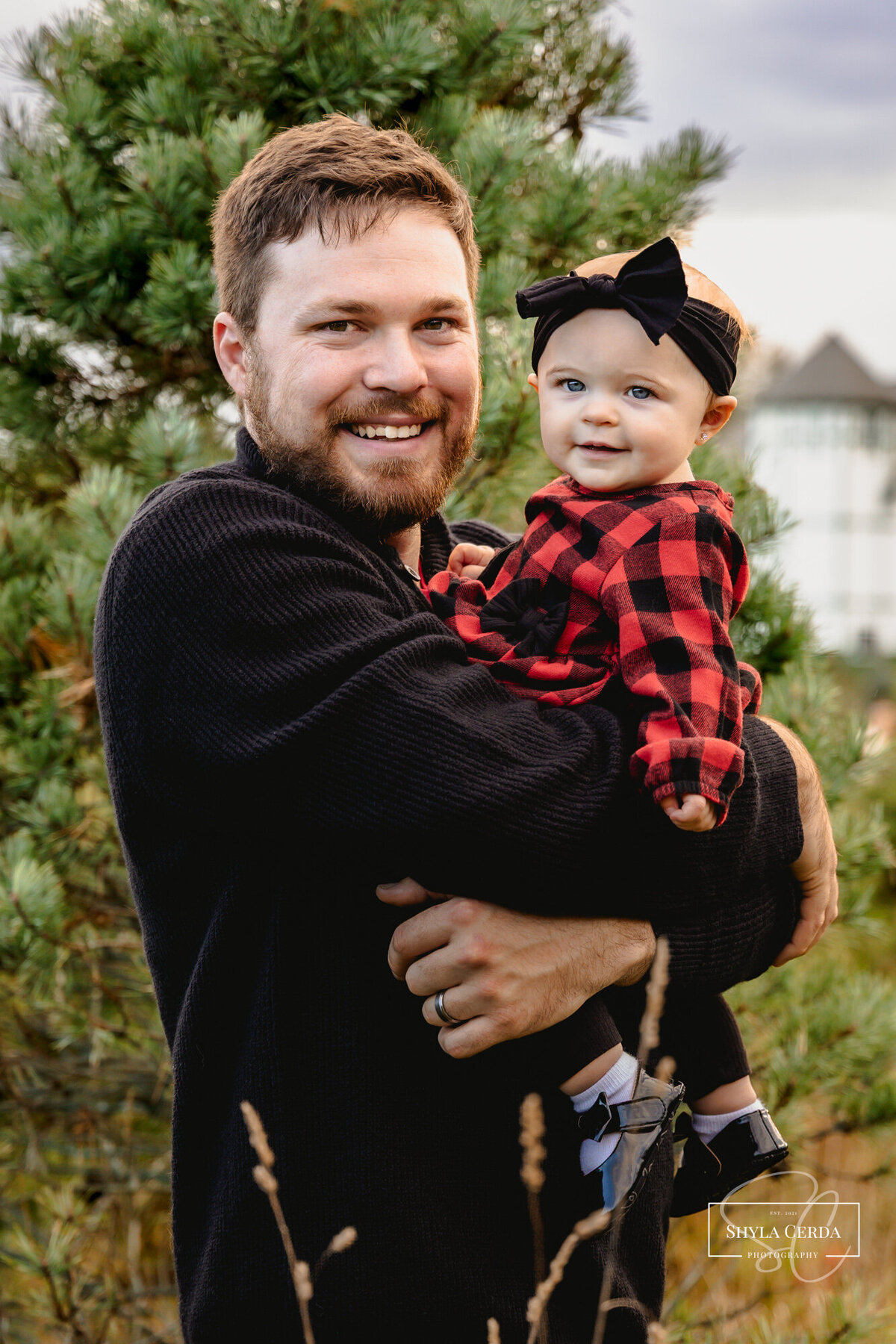 Dad holding daughter during outdoor session