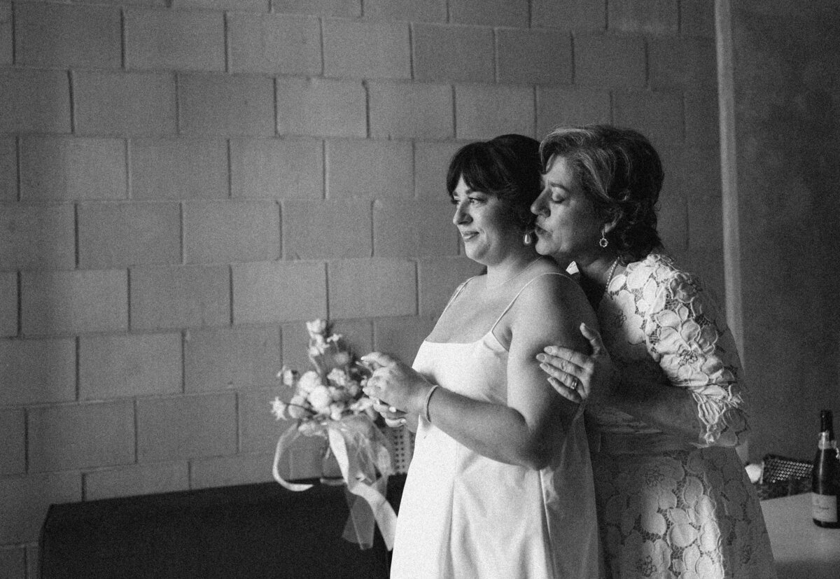 Bride with woman standing behind her  holding her arms