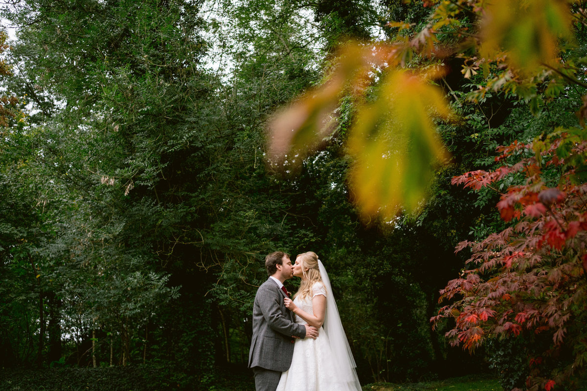 wedding couple kissing in the grounds at cripps barn
