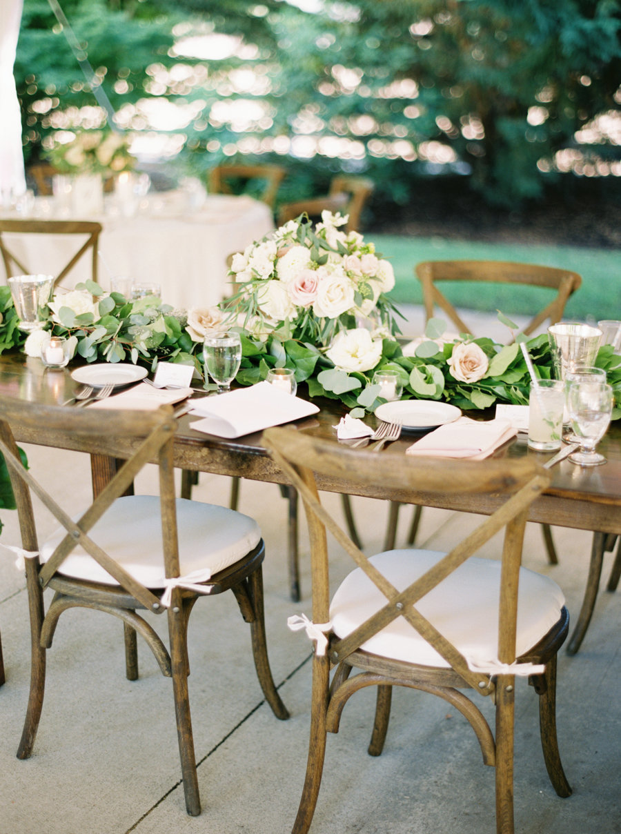 Wooden vineyard chairs are a perfect choice for this outdoor summer garden wedding designed by Flora Nova Seattle.