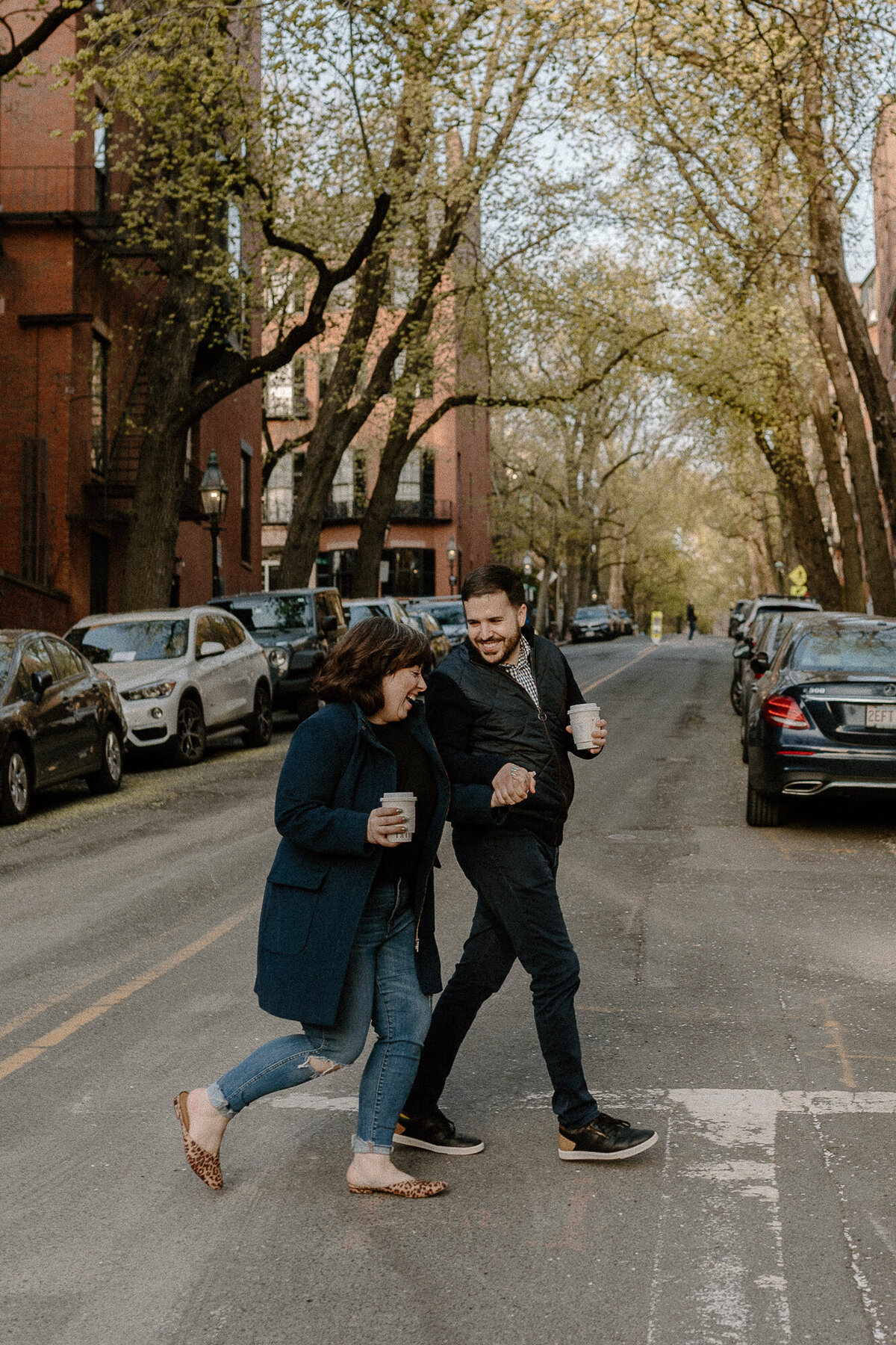 engaged couple walking with coffee