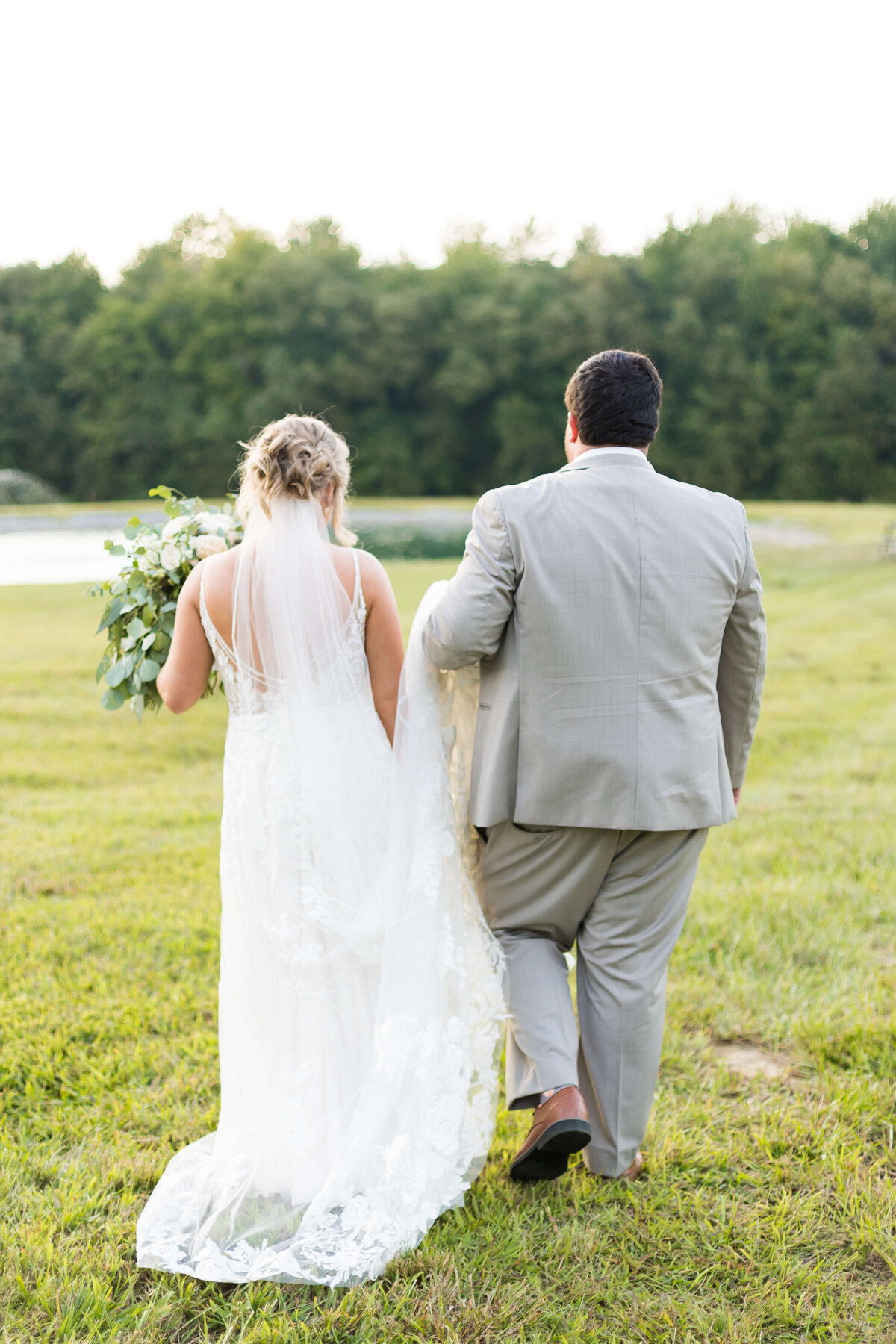 Bride and groom walking through the grounds at  The Barn at White Oaks, Murray, Kentucky