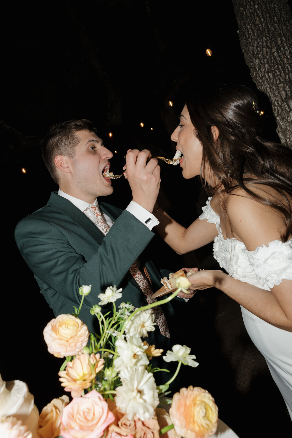 A bride and groom feeding each other cake at Lucky Arrow Retreat.