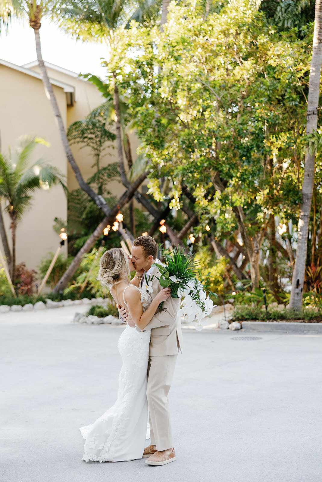 Ashley and Hunter share an intimate moment in a garden setting with fairy lights.