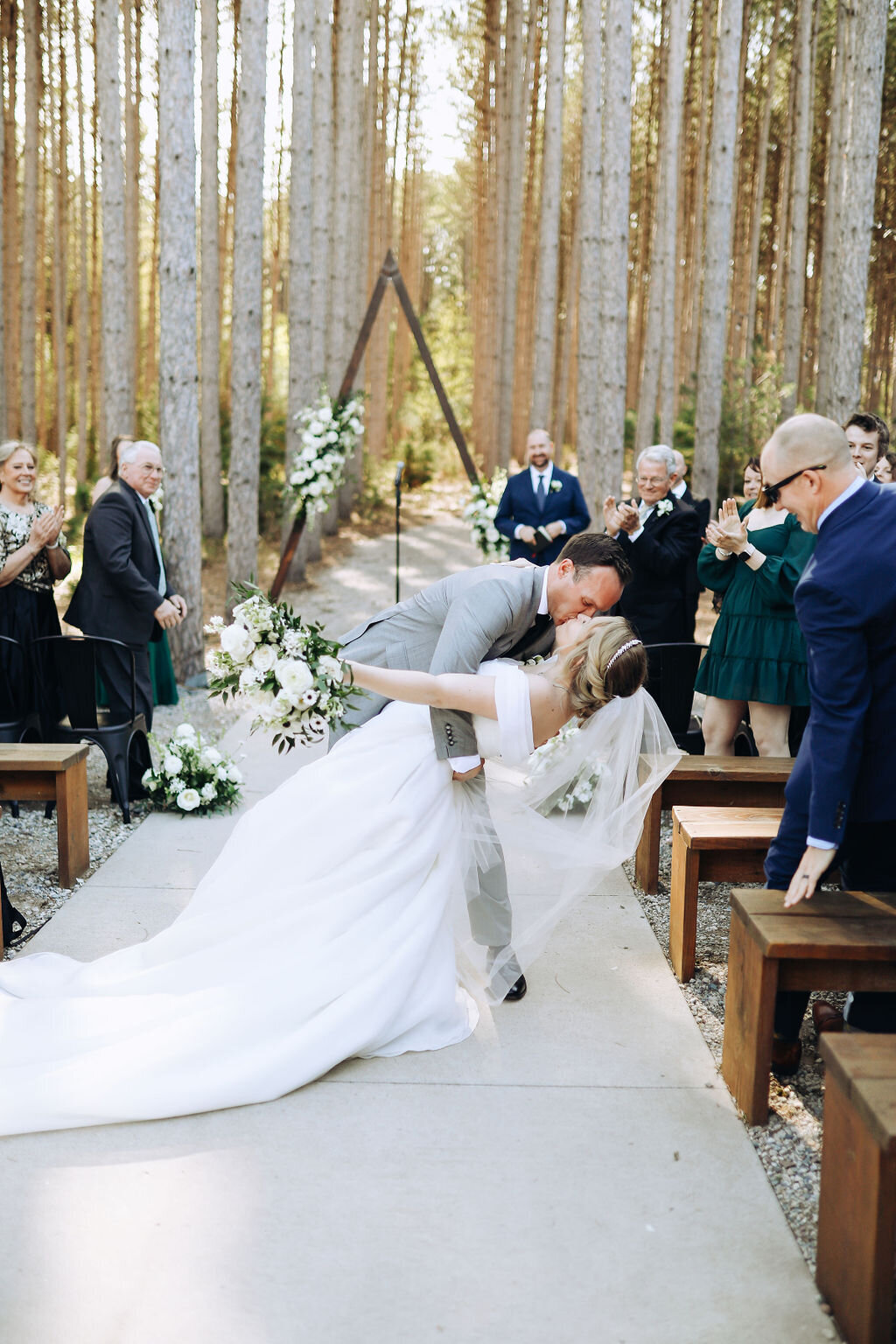 bride and groom dipping and kissing during ceremony at pinewood