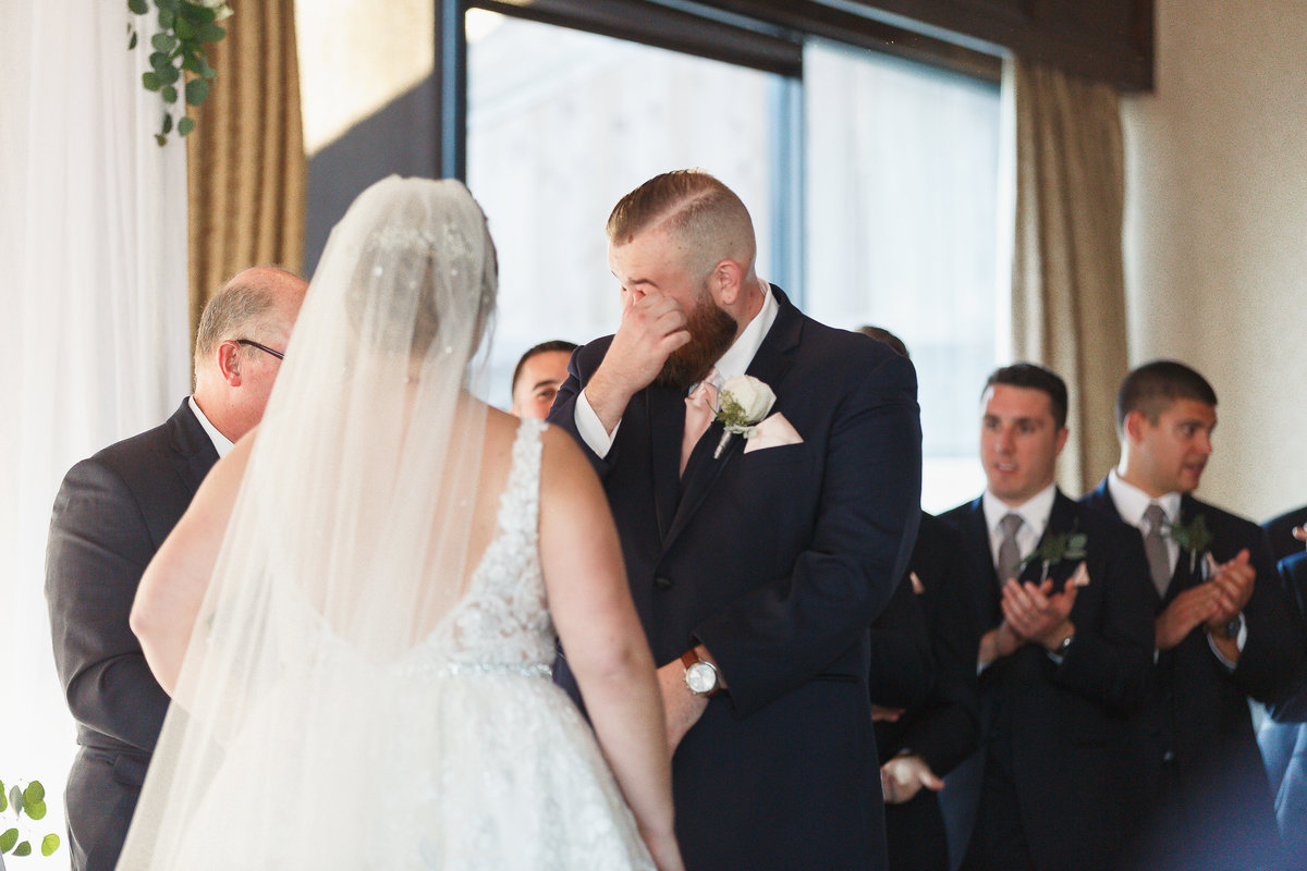 A Groom Wipes a Tear from His Eye During His Rusty Pelican Wedding in Tampa Bay Florida