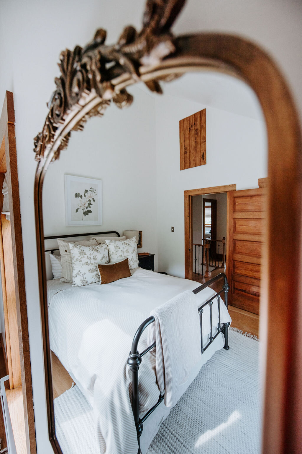 a mirror view image of the gold neutral bedroom in the modern farmhouse  overnight accommodations at the Willowbrook wedding venue