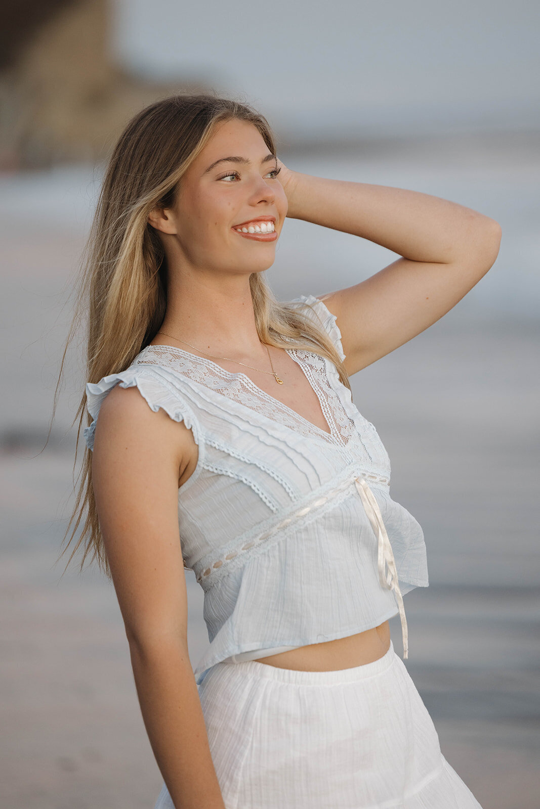 Senior girl running her hand through her hair on the beach