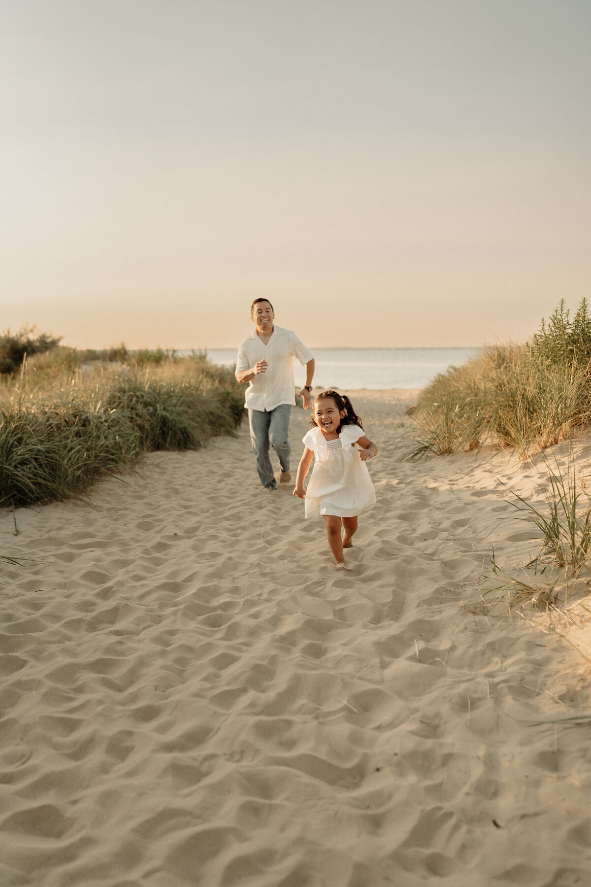 Dad and daughter running on the beach