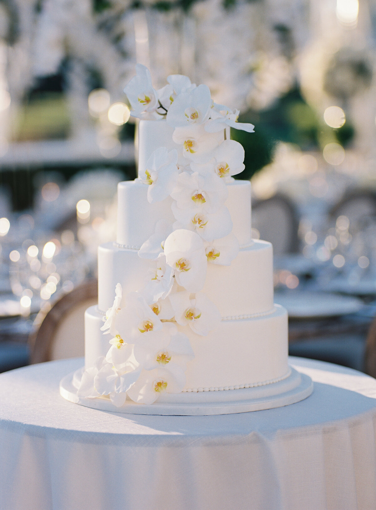 Close up of the wedding cake that is decorated with orchards. 