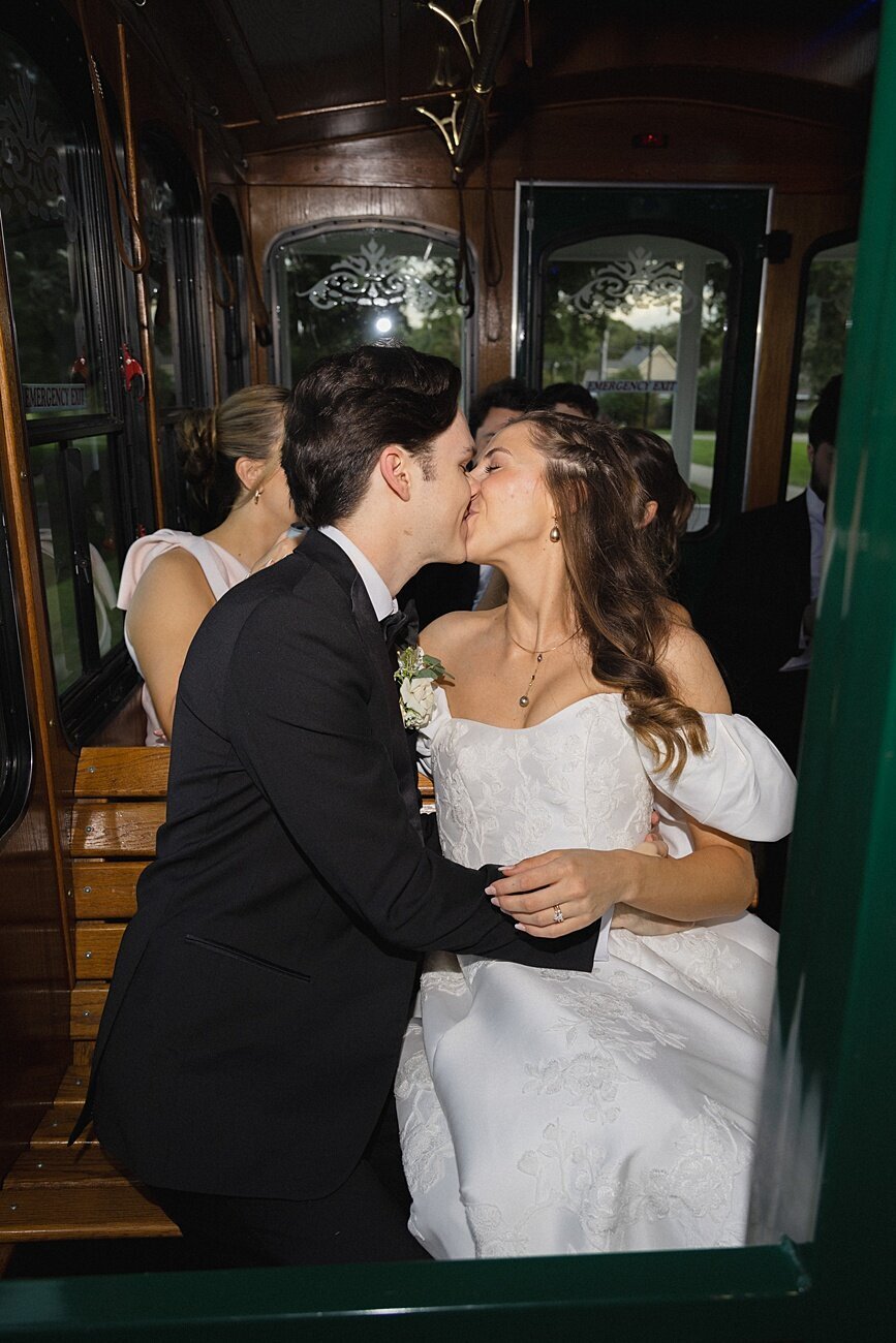 bride and groom kiss on party bus