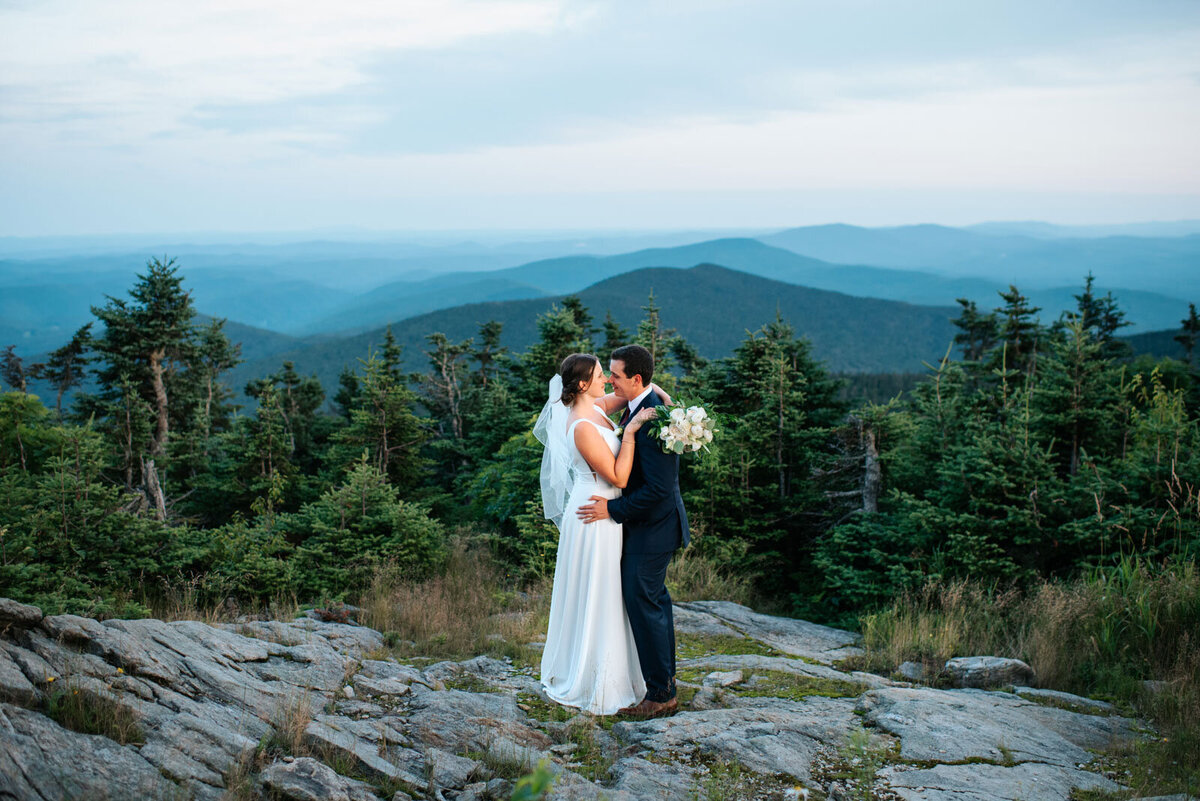 bride and groom kissing on top of killington mountain peak lodge wedding