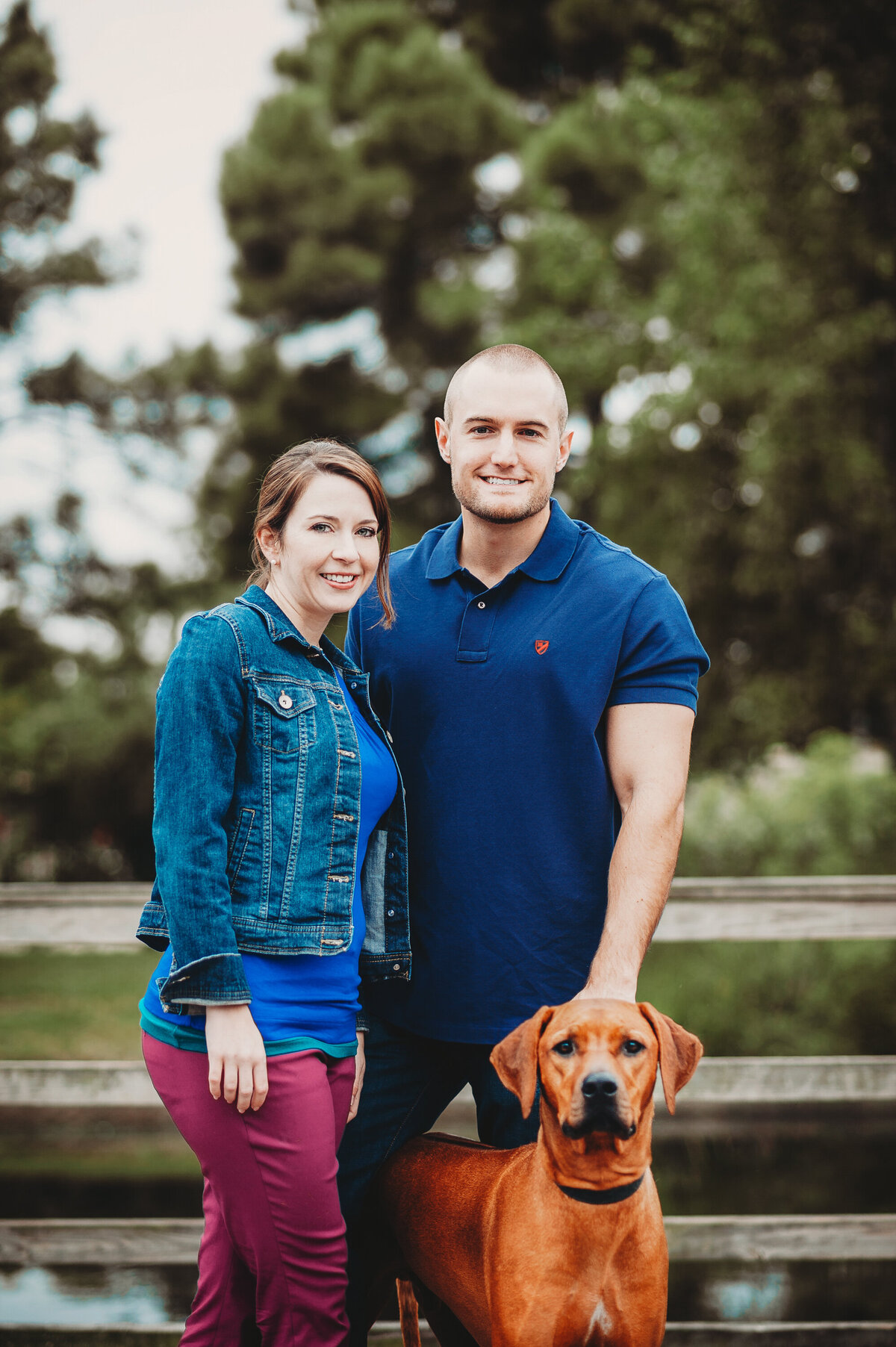Couple posing with their dog on  during a family-style portrait session in Winter Garden, Florida.