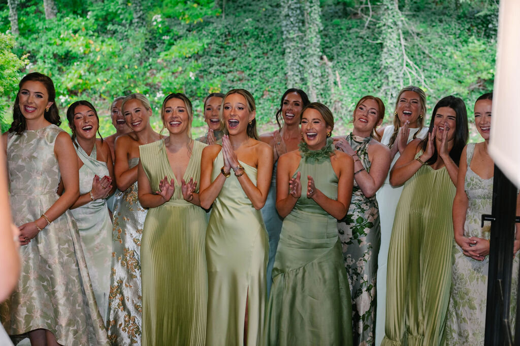 Bridesmaids smiling and cheering during the bride’s first look moment at The Bascom in Highlands, North Carolina.
