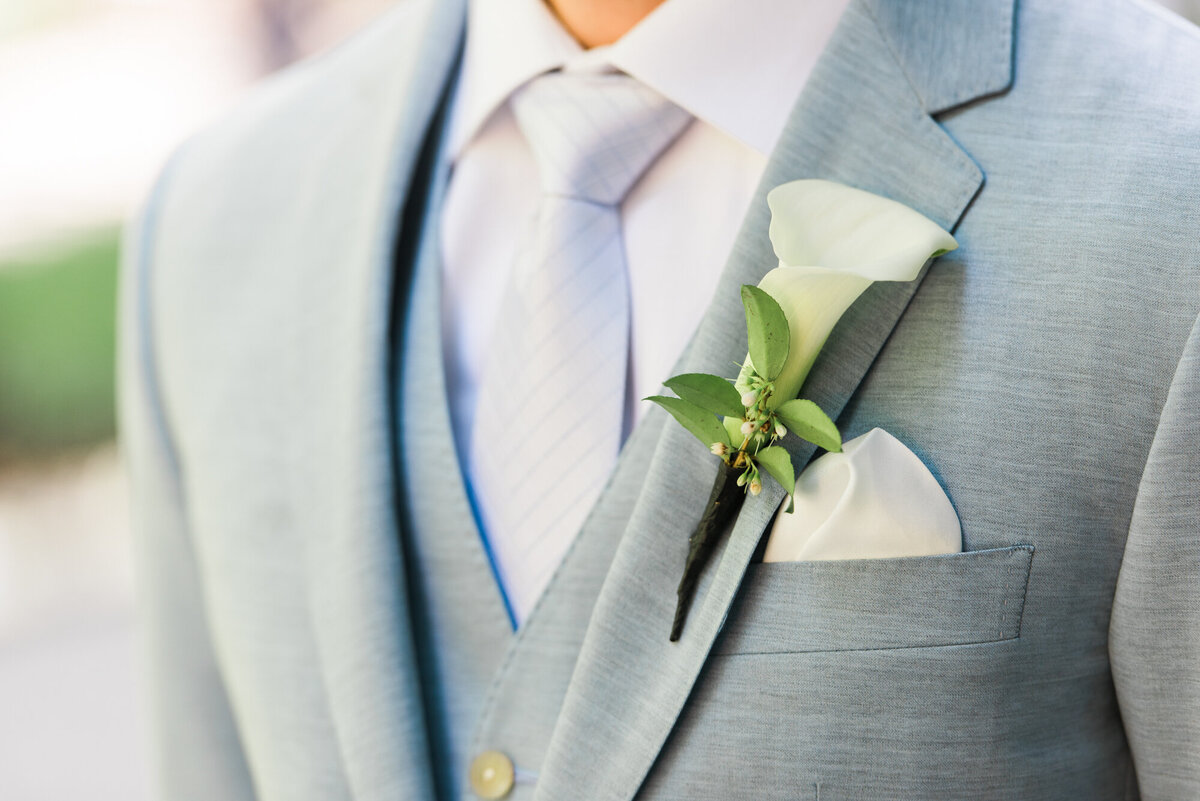 Groom in gray suit with boutonniere