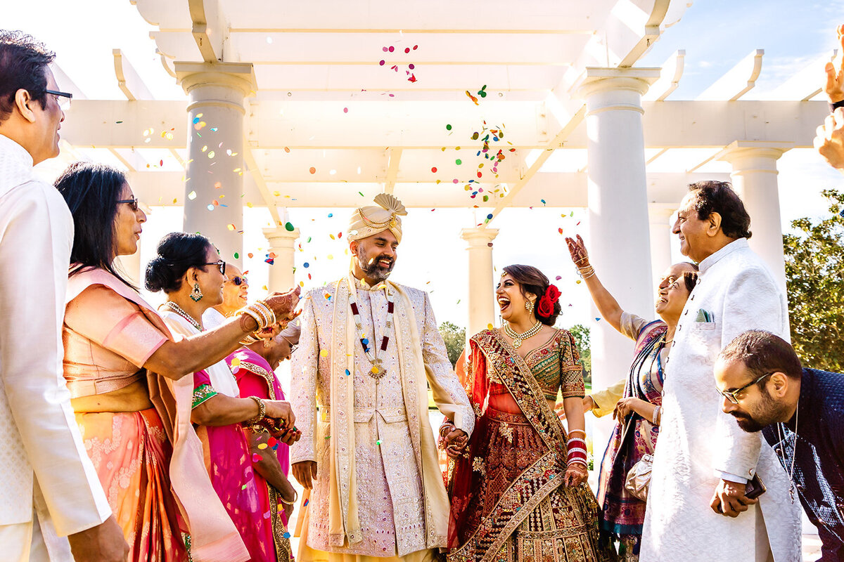 A bride and groom sharing a romantic dance under arches, illuminated by soft golden lighting, creating a dramatic and intimate moment. Captured by Shannon, an Orlando, Florida Indian Wedding Photographer.