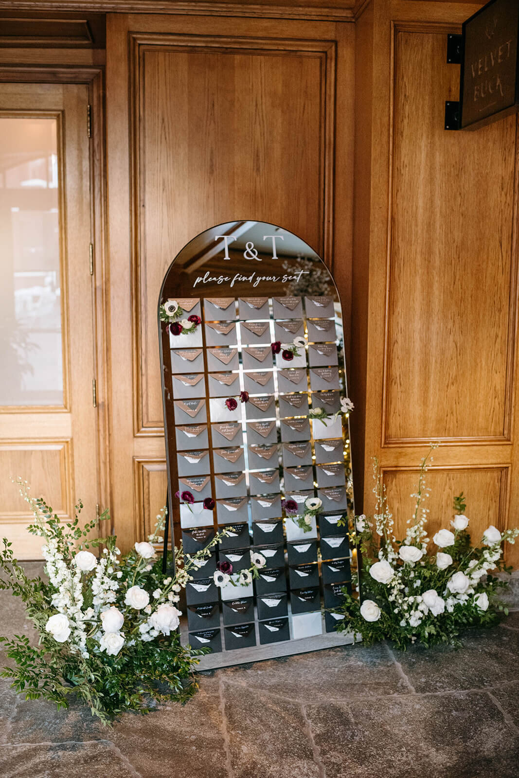 Elegant wedding escort board on a mirror at St. Regis Aspen, featuring delicate calligraphy and a sophisticated design.