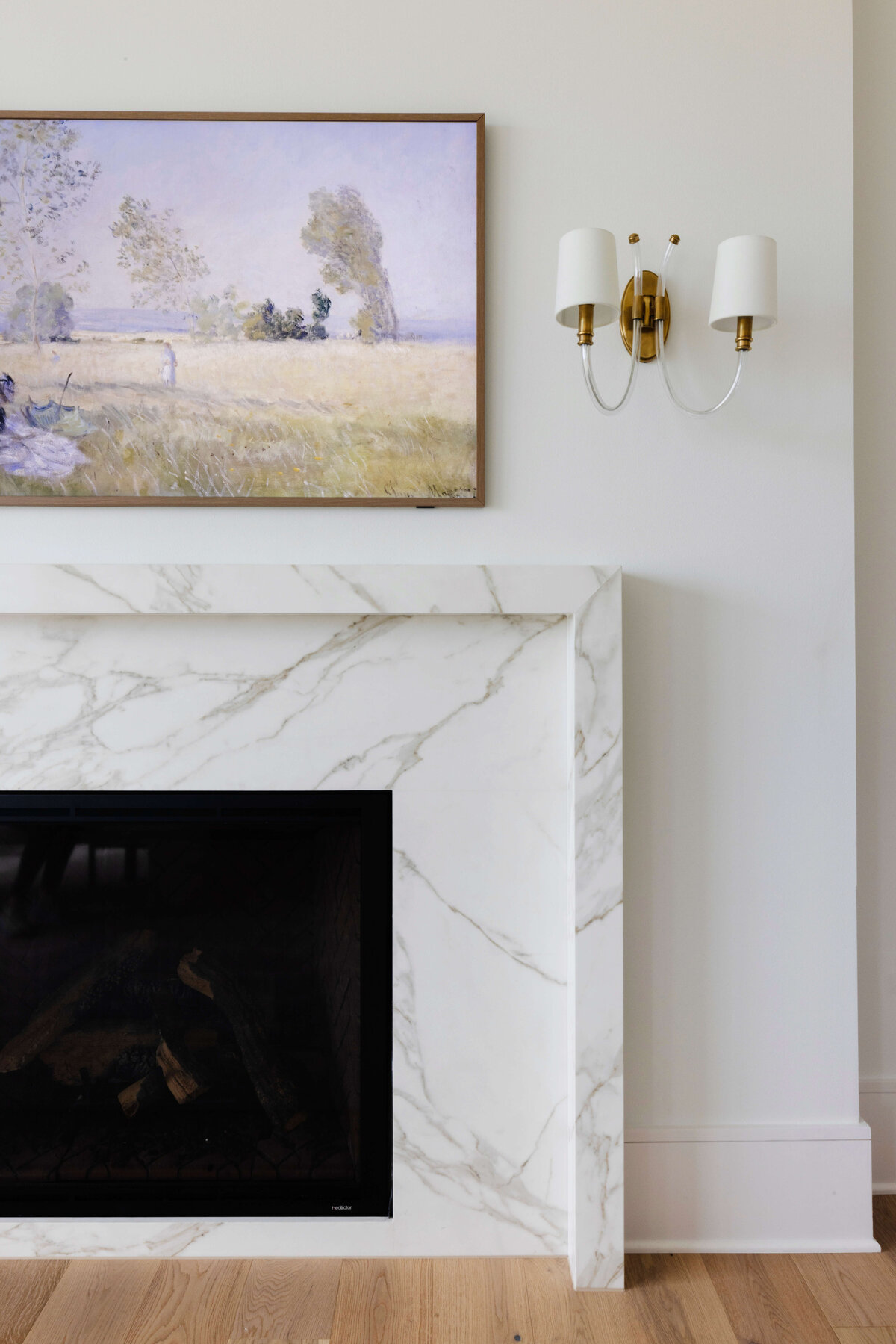 oyster creek studios hughes marble fireplace with modern artwork and gold lighting