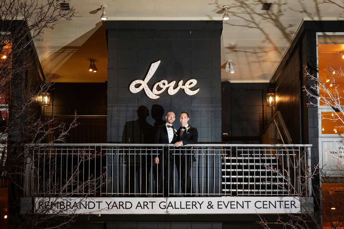 two grooms on the balcony under the Love sign