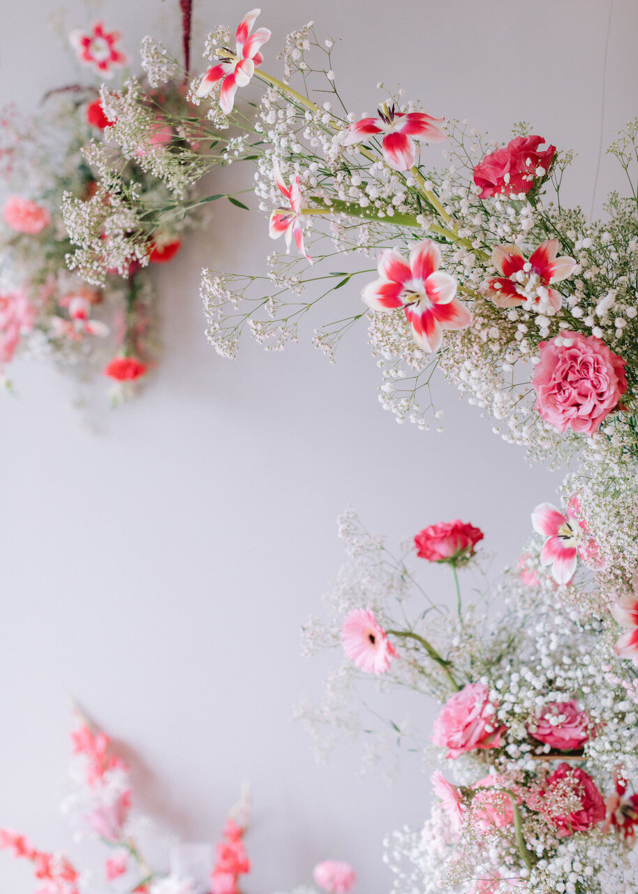 Delicate floral installation with pink and white blossoms arranged in a whimsical, organic design