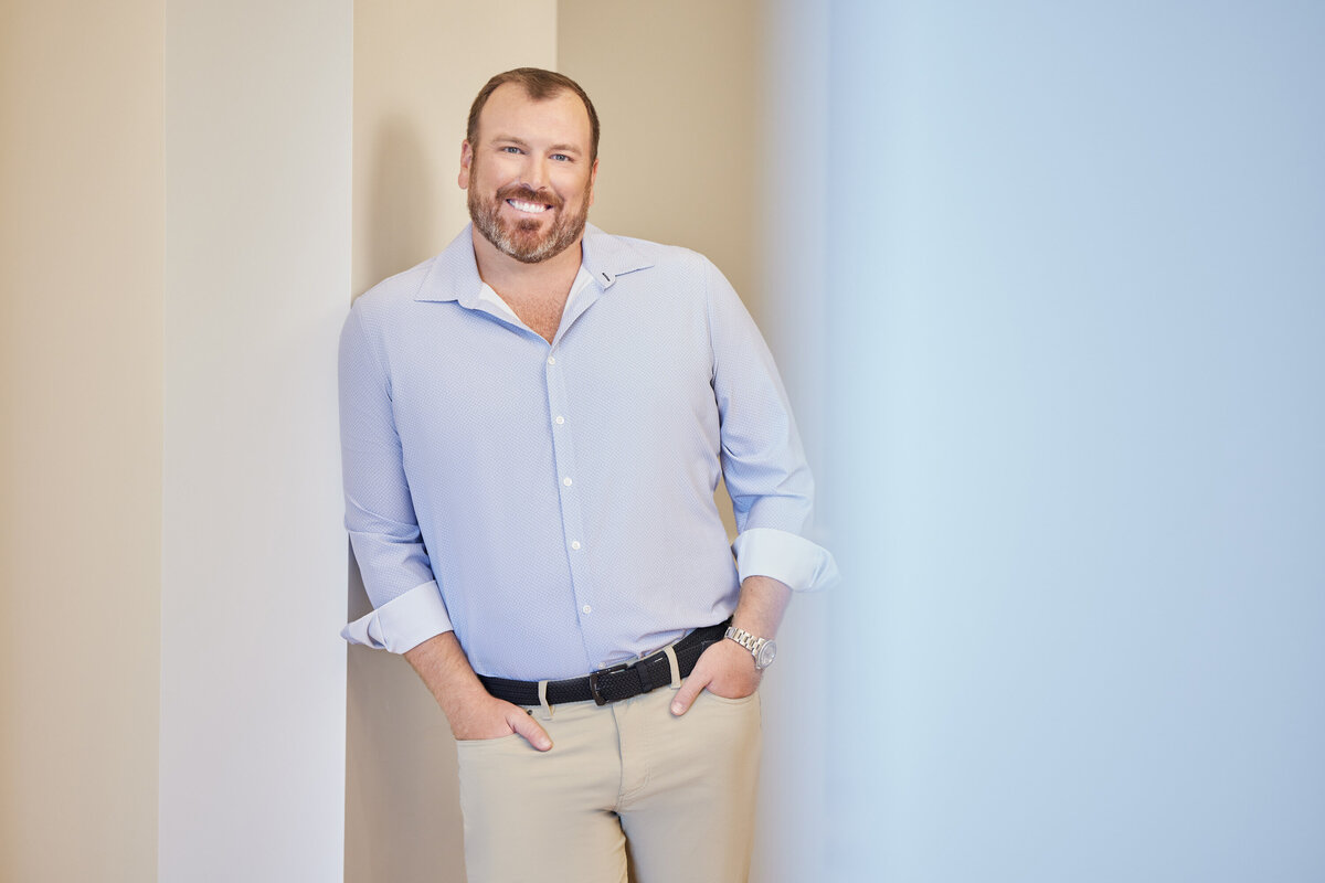 A man leaning against the wall with his hands in his pockets