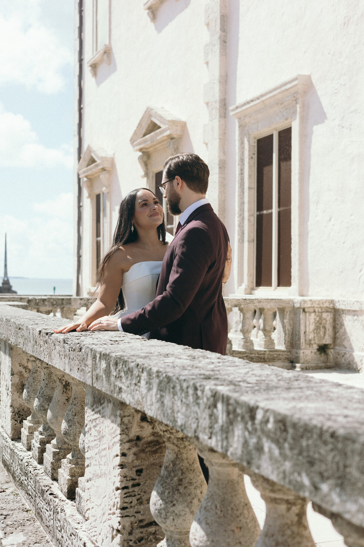 Bride and groom looking at each other over Vizcaya Museum and  Gardens building in Miami, Florida.