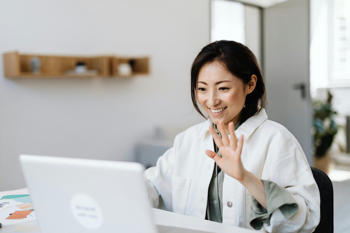 woman on computer waving