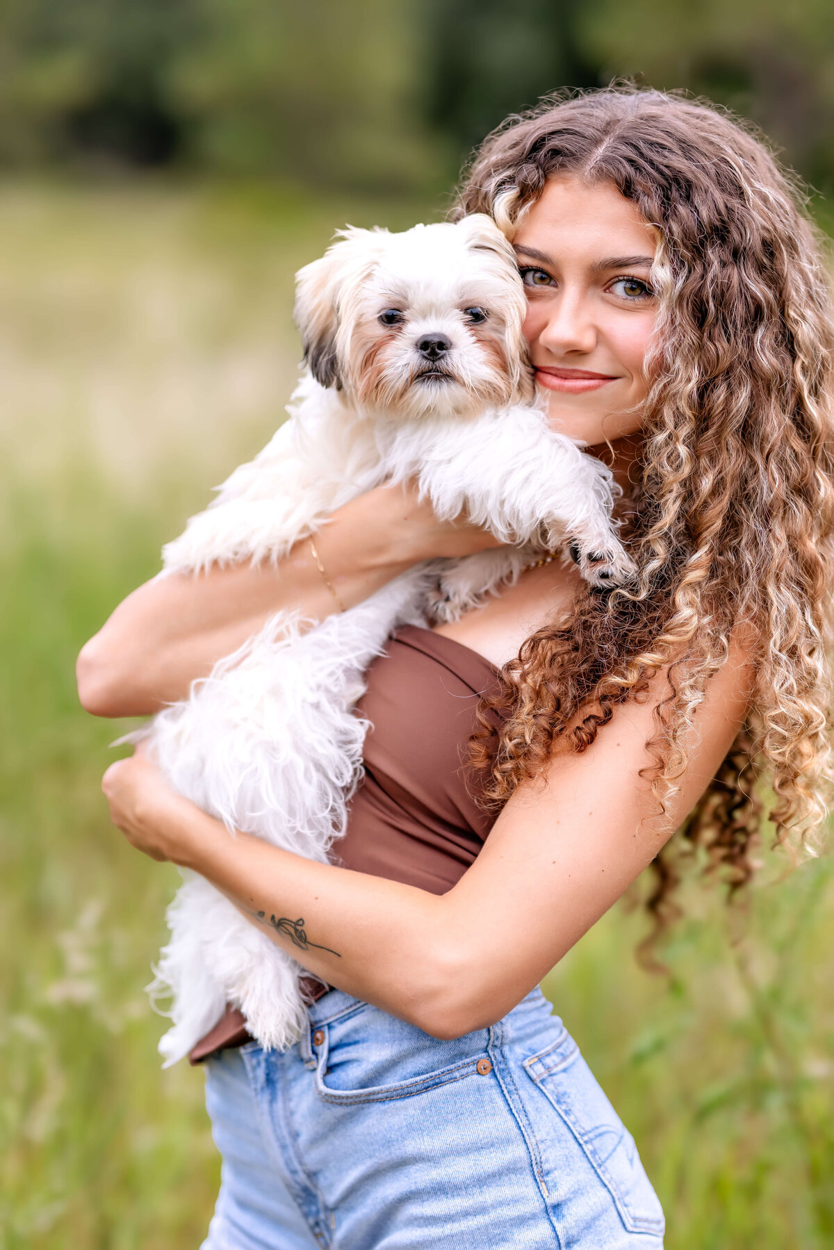 Sweet senior pictures in Windermere with a teen girl cuddling her puppy during her photoshoot.