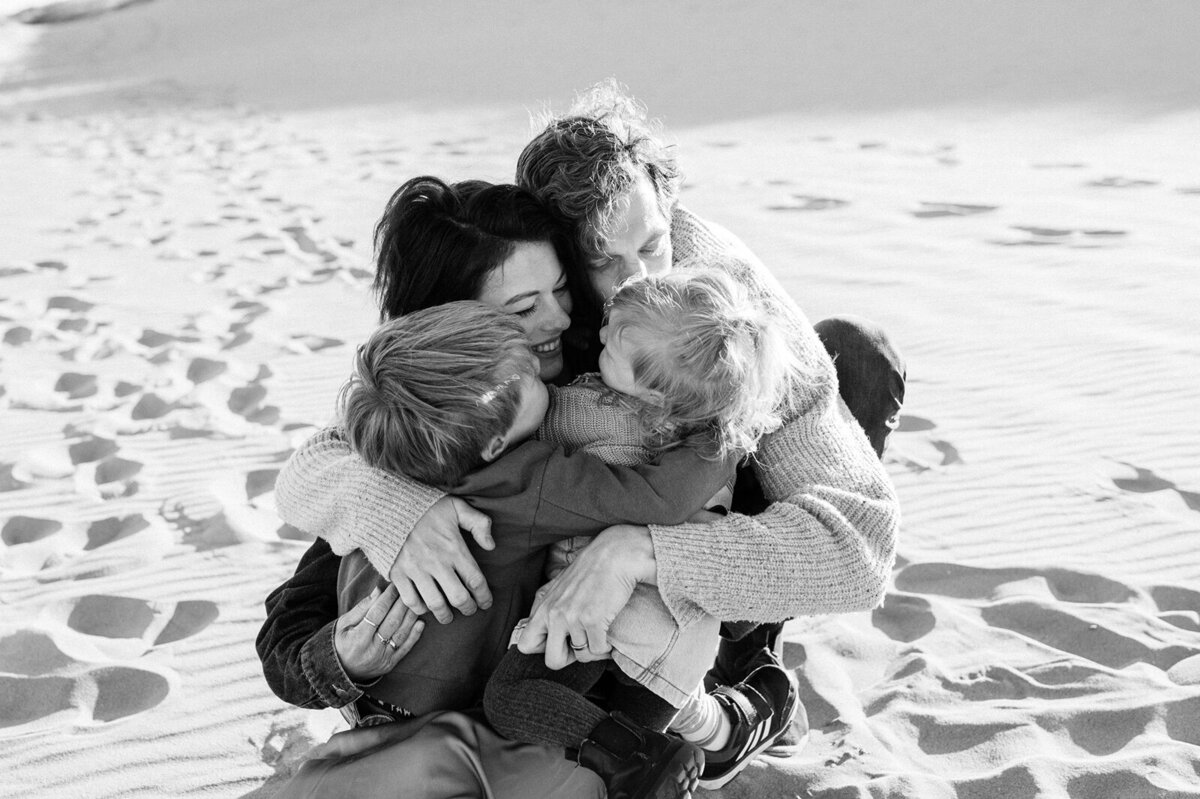 Knuffelend gezin op het strand