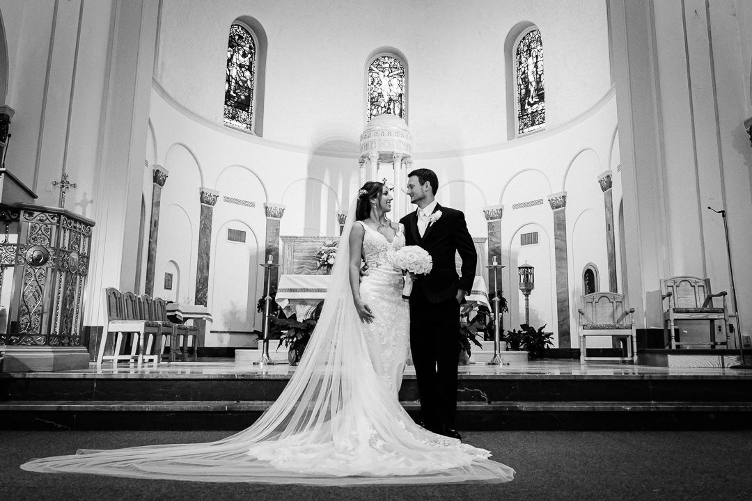 Bride and groom share a kiss at the church altar after their wedding ceremony, captured by Alex Kaplan Photography.