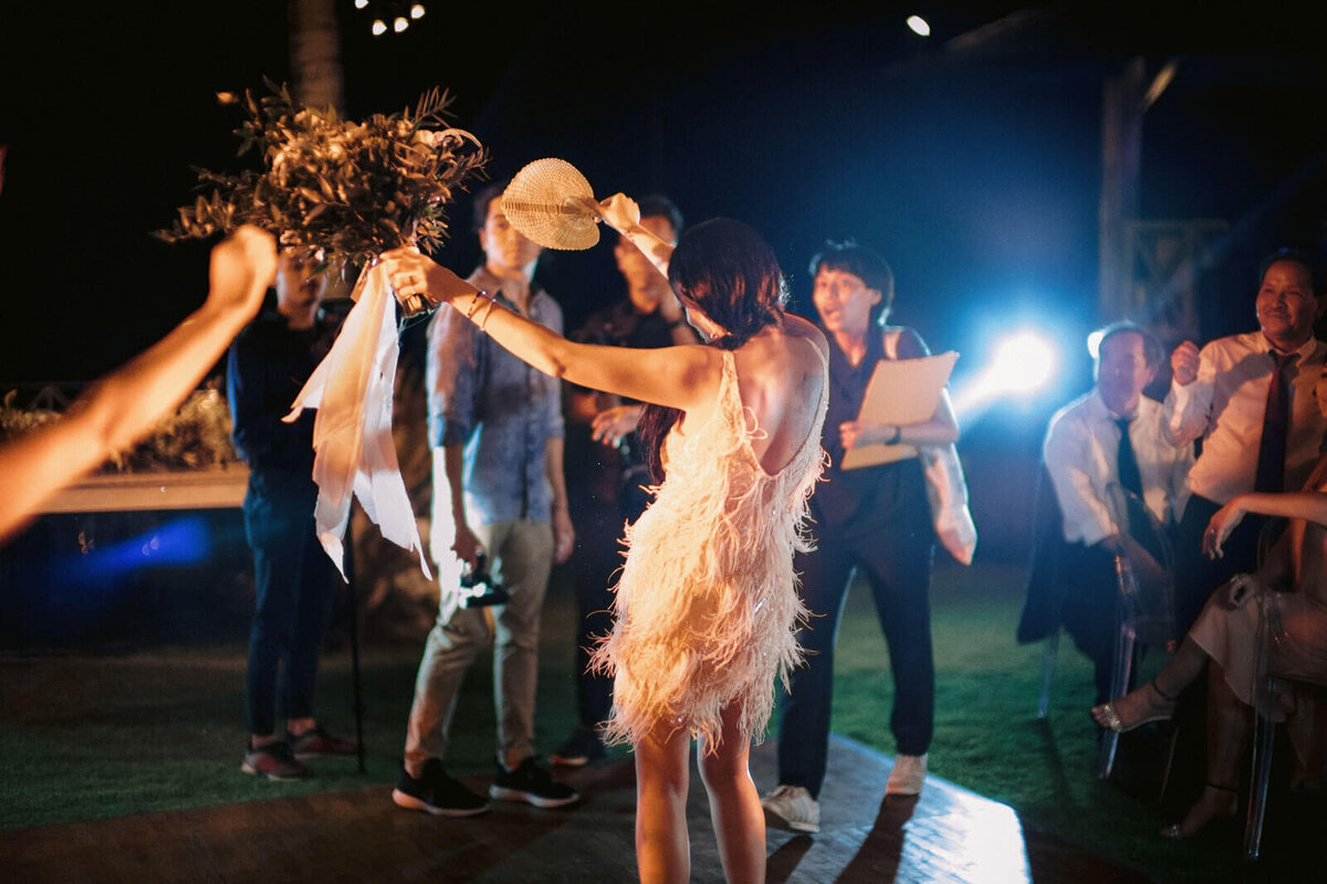 The bride is dancing, wearing her after-party dress, in Khayangan Estate, Bali, Indonesia. Image by Jenny Fu Studio