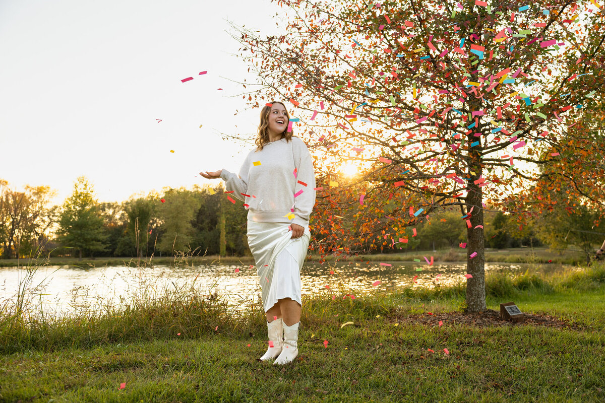 Senior girl standing under falling confetti in Lawrence KS