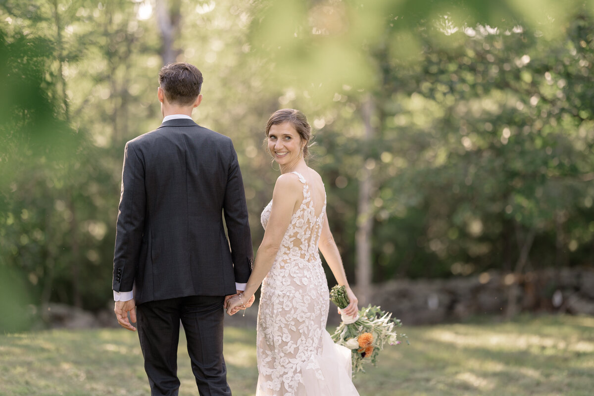 timeless image of bridal and groom walking with bride looking over her shoulder