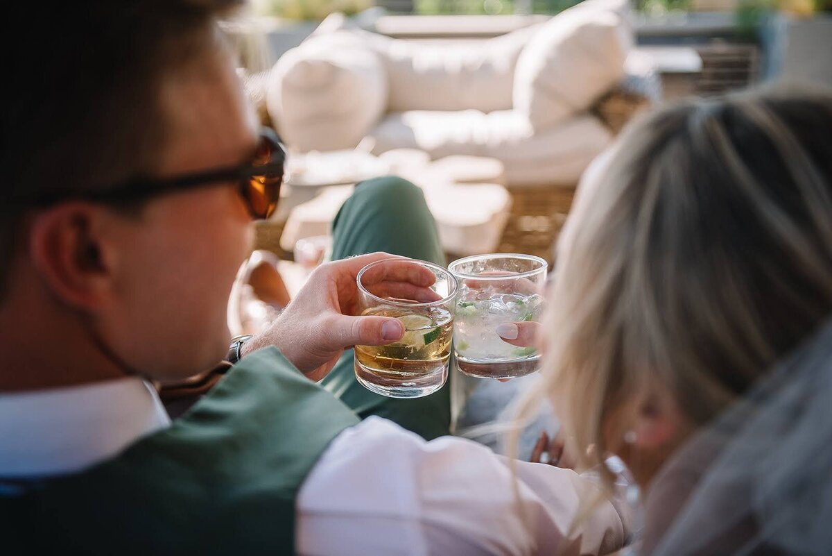 Bride and groom cheers their drinks on their wedding day.