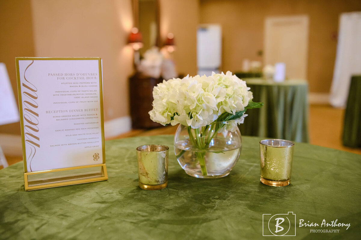 Stylish wedding reception table featuring lush floral arrangements and gold details.