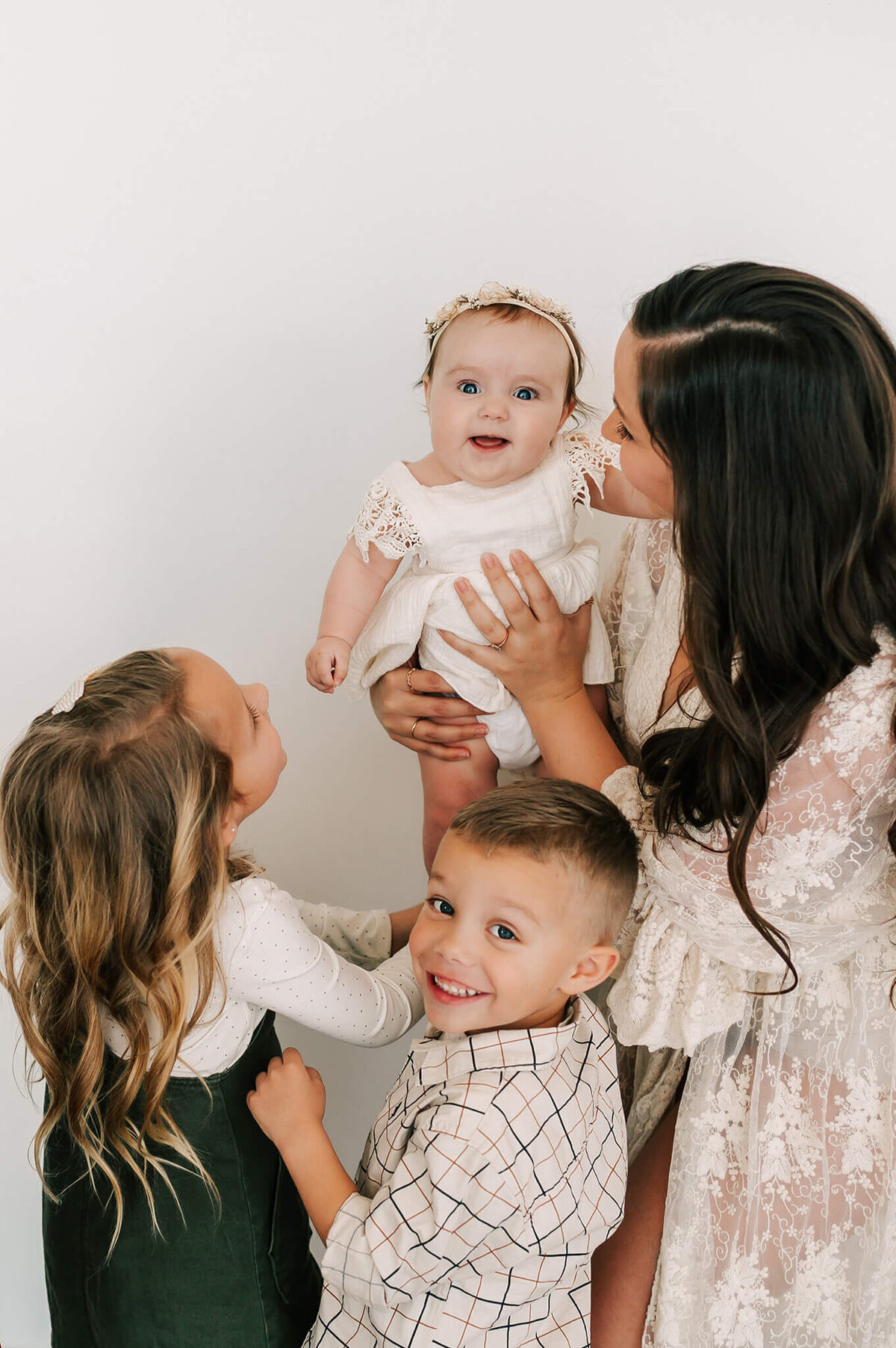 mom and kids smiling at baby enjoying Springfield MO family photography