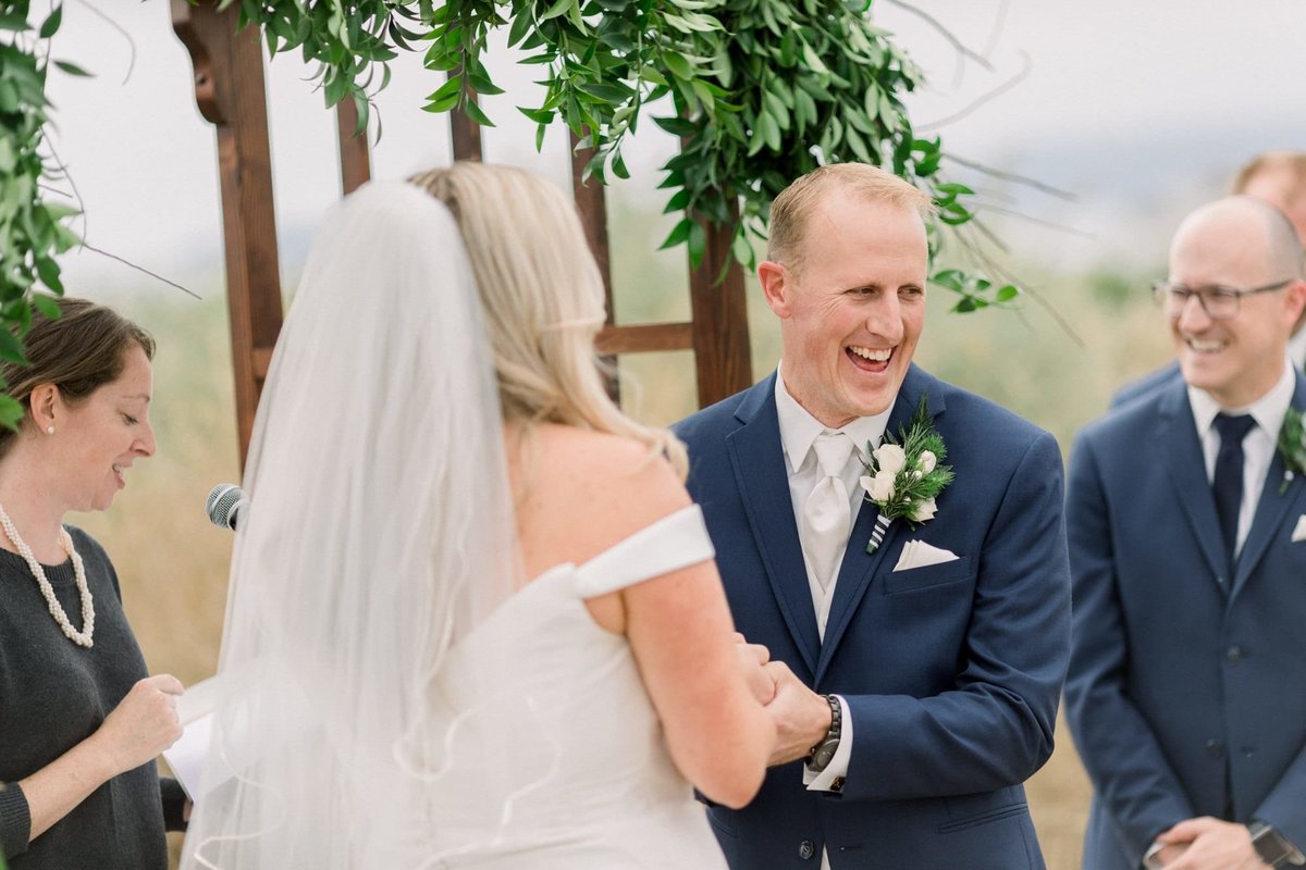 Groom turns to the audience during the wedding ceremony and laughs