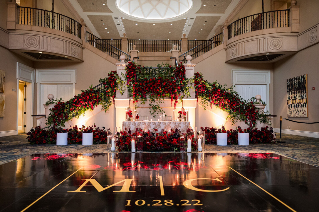 Sweetheart table, hanging amaranthus, black and gold dancefloor, red flowers, sweetheart table, staircase flowers