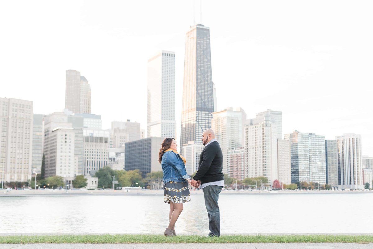 Couple holding hands over looking Chicago's skyline at Milton Olive Lee Park