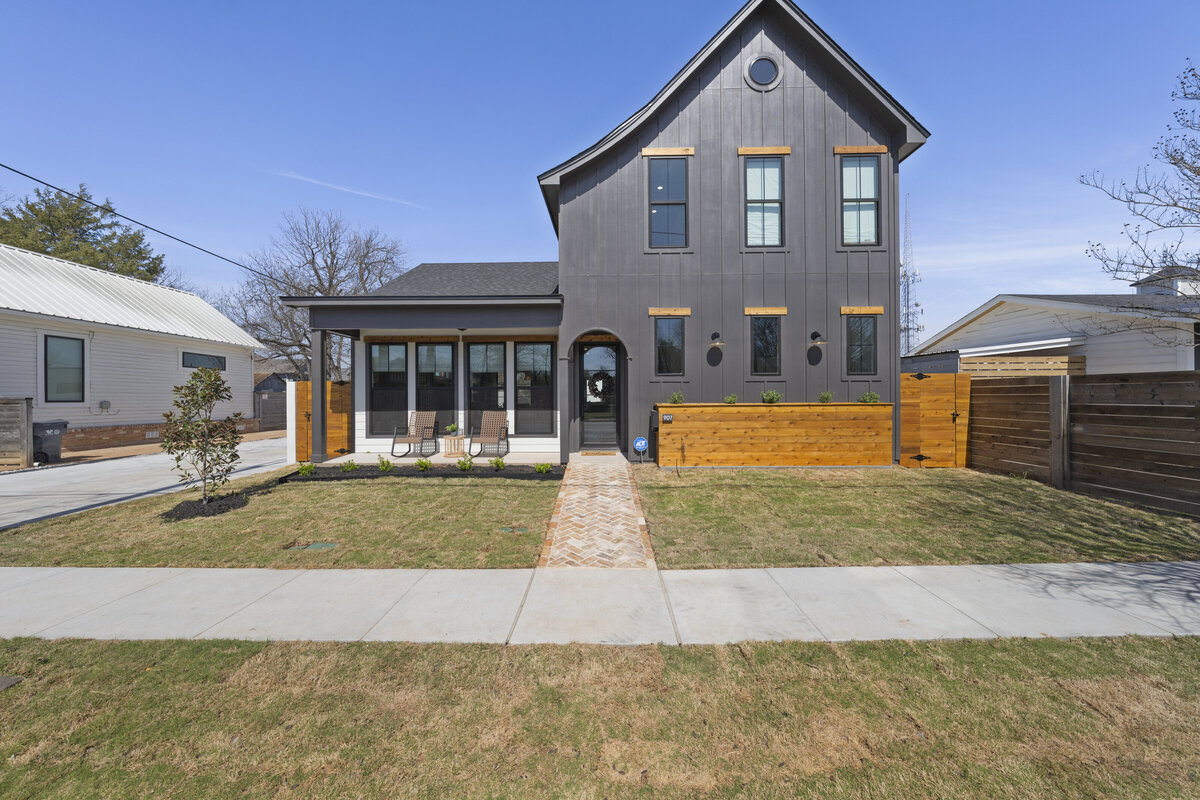 Fenced-in front yard and beautiful front view at this two-bedroom, two-bathroom house with wine fridge, firepit, and two master suites located in the heart of the Silo District in Waco, TX.