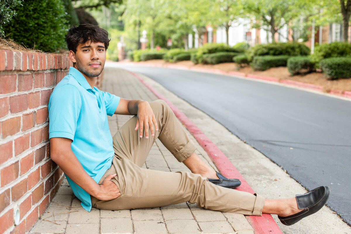 Urban Spring senior photo session boy sitting on the sidewalk by photographer Laure Photography