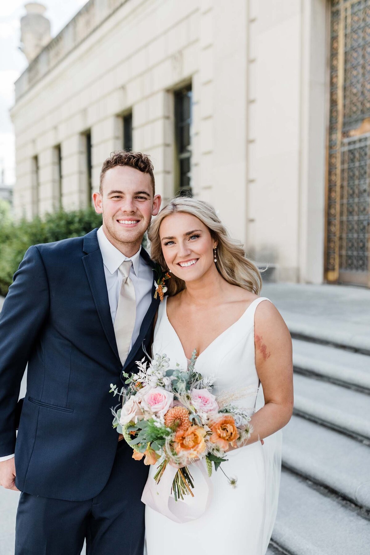 Couple celebrating their wedding outdoors on the steps of a South Bend venue.